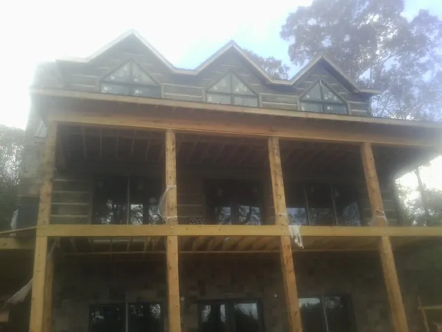 Dormers and porch framing on a large log home under construction — Roof Coating work by our crew in Scottsburg