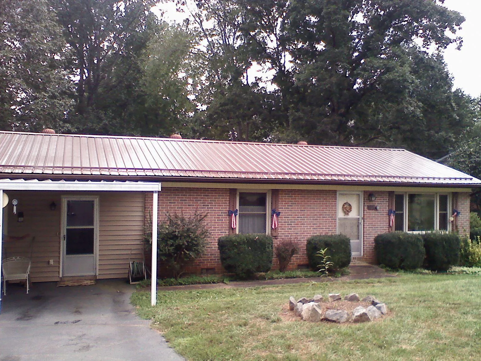 Bronze metal roof and carport on a brick ranch home — Roof Repair work by our crew in Scottsburg